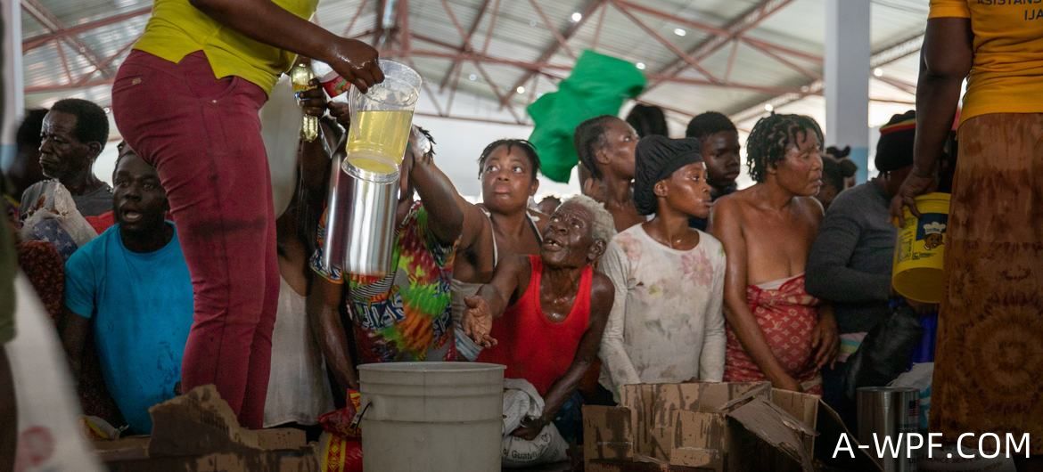 海地太子港一个受帮派影响地区的居民正在接受世界粮食计划署的粮食援助。